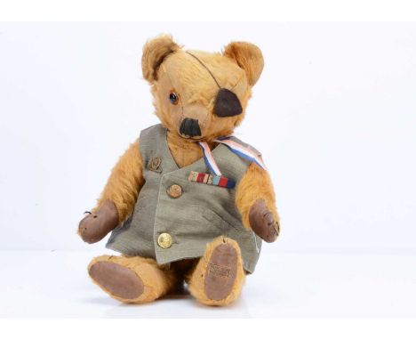 A late 1930s Merrythought teddy bear,  with dark golden mohair, orange and black glass eye, black stitched nose, mouth and cl