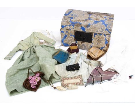 A mid 19th century doll’s trunk with clothing, a blue, grey and white floral hand printed paper covered domed wooden trunk wi