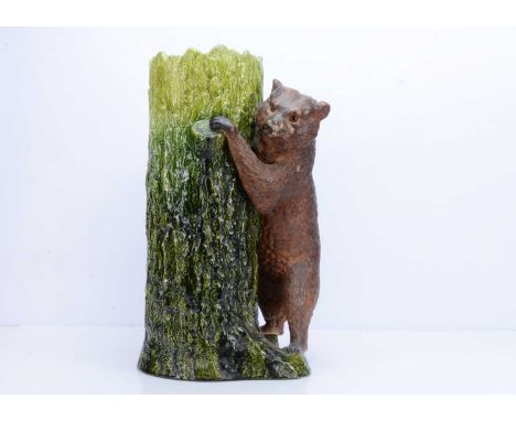 A early 20th century Bretby pottery bear umbrella stand, in the form of a green glazed tree trunk with brown glazed bear stan