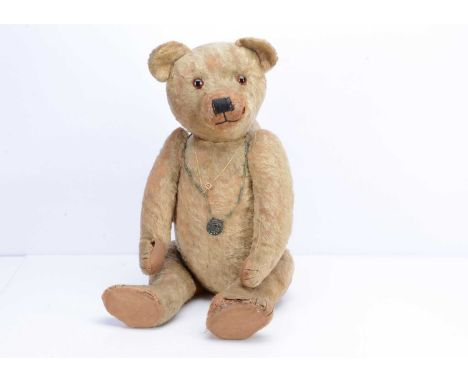 A large 1920s British teddy bear,  possibly Chad Valley, with orange and black glass eyes, pronounced  shaved muzzle, black s