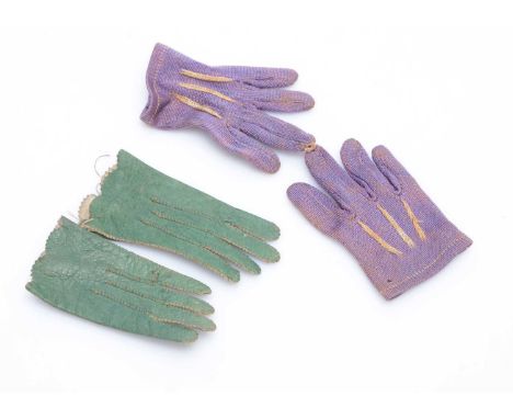 Two pairs of fashion doll’s gloves,  a green leather pair —2in. (5cm.) long (missing button) and a purple cloth pair