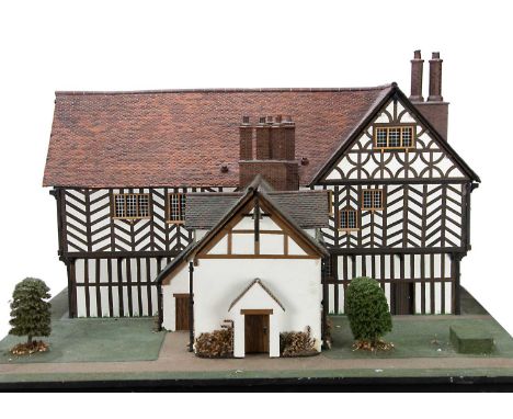 A very detailed model miniaturist small scale large Tudor dolls’ house mounted on a landscaped board, to be looked at in the 