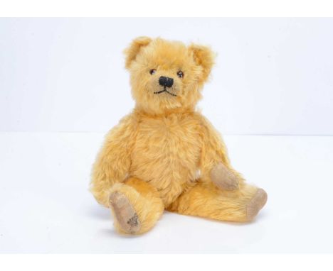 A post- war Farnell teddy bear,  with golden mohair, orange and black glass eyes, black stitched nose and mouth, swivel head,