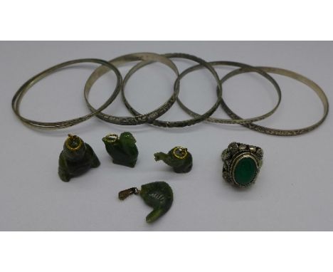 Four jade charms, a white metal set jade poison ring, two sterling silver Candida bangles and other silver and white metal ba