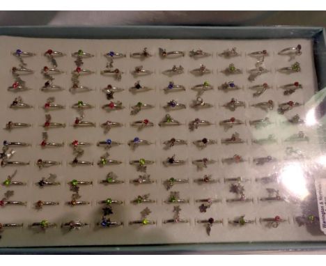 One hundred costume rings with tags in tray. UK P&amp;P Group 1 (£16+VAT for the first lot and £2+VAT for subsequent lots) 