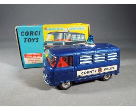 Corgi Toys - A boxed 464 Commer Police Van. The model has a dark blue body, red interior, and spun hubs. The model is in Exce