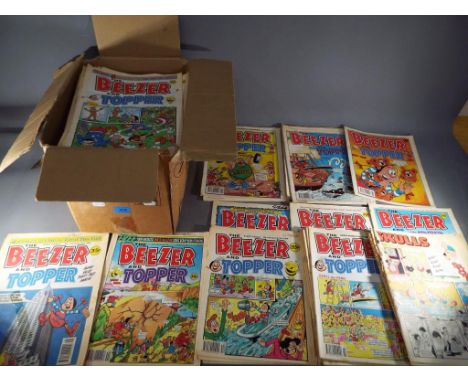 A box containing a quantity of vintage comics including Beezer, Topper, Whizzer and Chips.
