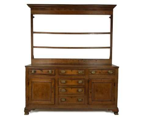 Georgian Oak Dresser. Two cupboard doors to reveal fixed shelf to each, six drawers with stamped gilt brass handles and bande