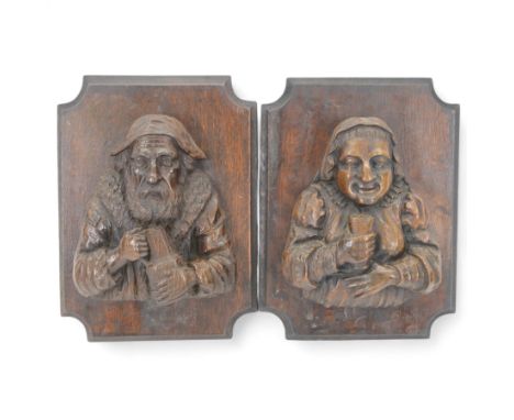 Pair of carved oak figures, modelled as a man and woman in traditional dress, each holding tankards, upon shaped rectangular 