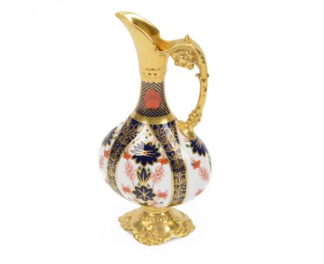 Late 20th century Royal Crown Derby Imari 1128 pattern Kedleston ewer, with gilt scroll handle and neck, upon a gilt quatrefo