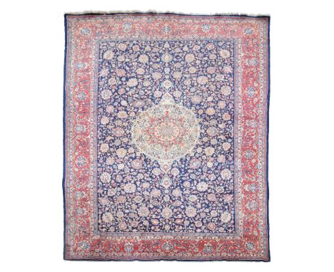 A Kirman carpet, the central medallion within a field of meandering foliage...  A Kirman carpet,   the central medallion with