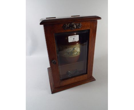 An Edwardian Oak Smokers Cabinet with Ceramic Pot.