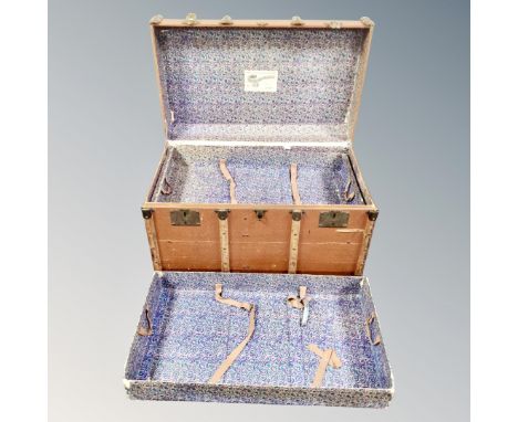 An early 20th century bentwood shipping trunk with lift out trays bearing labels 