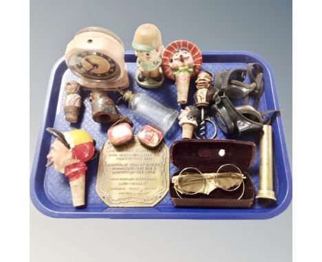 A tray containing assorted collectables to include novelty cork screw and bottle stoppers, vintage glasses and goggles, mid c