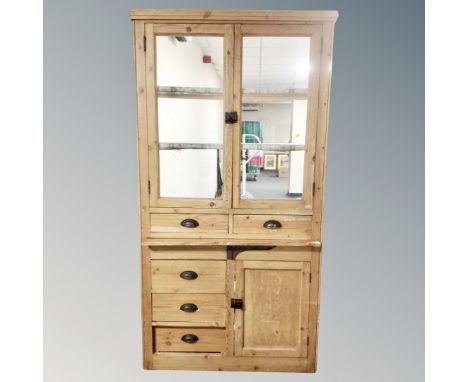 An antique pine double door glazed kitchen cabinet with cupboards and drawers beneath (no back panel)