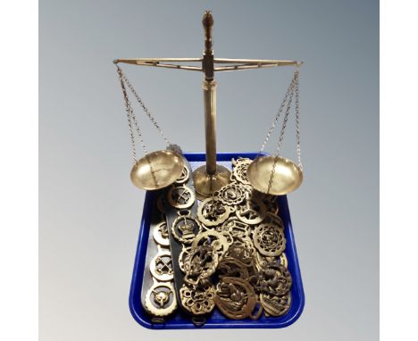 A set of vintage brass pan balance scales together with a large quantity of horses brasses, some on leather straps. 