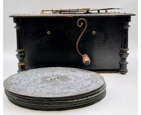 A late 19th century ebonised polyphon; Atlas Organette, together with 19 metal discs. H.23 W.45 D.37.5cm (not working)