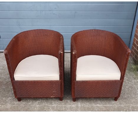 A pair of 20th century Lloyd Loom machine woven iron red painted kraft paper tub chairs each having a curved back and arms ov