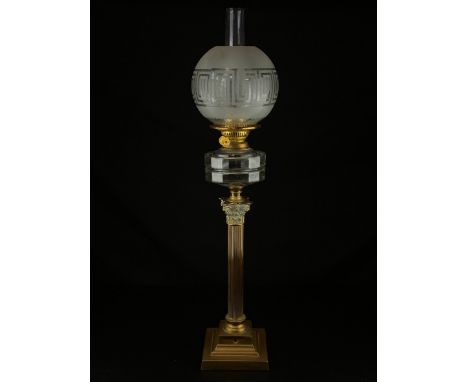 A Victorian brass Corinthian column oil lamp having a frosted greek key glass globe and plain chimney above a shaped glass re