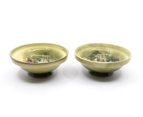 A pair of Moorcroft 'Spring Flower' small footed bowls designed by Walter Moorcroft on light green ground. Diameter approx 11