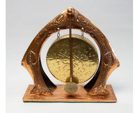 An Arts & Crafts movement copper and brass dinner gong. With hammered copper and etch marks to the brass gong, with an art no