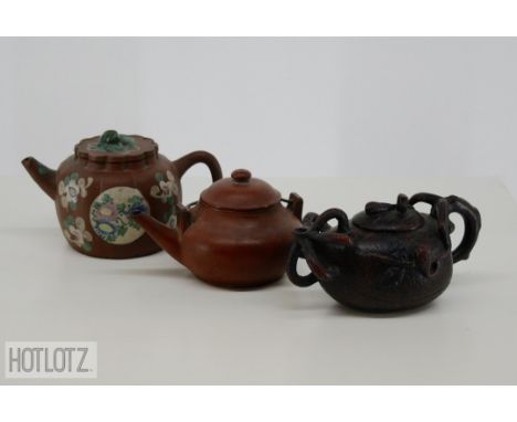 THREE CHINESE YIXING POTTERY TEAPOTS
Comprising: a lobed example with floral enamel decoration; one naturalistically modelled