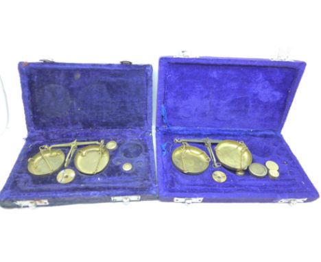 Two cased sets of weighing scales 