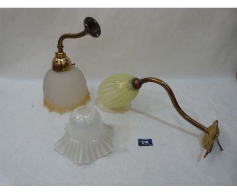 Period lighting. Two brass wall lamps, one with a Vaseline glass shade, the other a frosted amber flasked shade together with