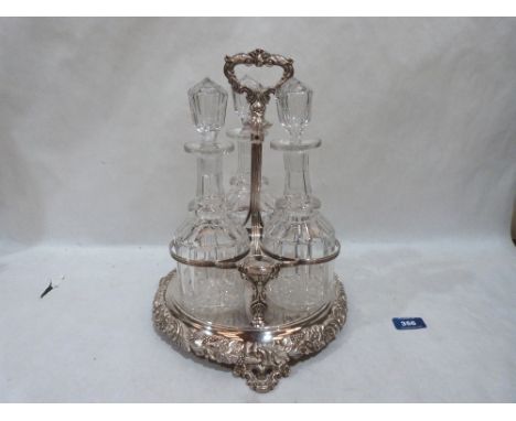 A plated decanter stand with three cut glass mallet decanters, the stand moulded with vine fruits, shells and paterae. 13' hi