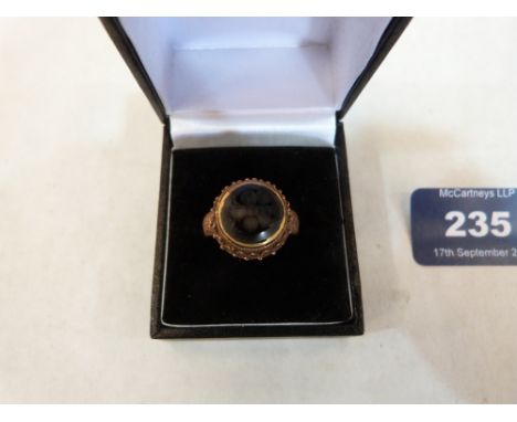 An Islamic gilt ring set with an intaglio black stone. Size O½