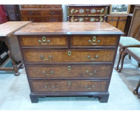 A George III mahogany and burrwood (probably yew) chest of two short over three long drawers on ogee bracket feet. 37½' wide