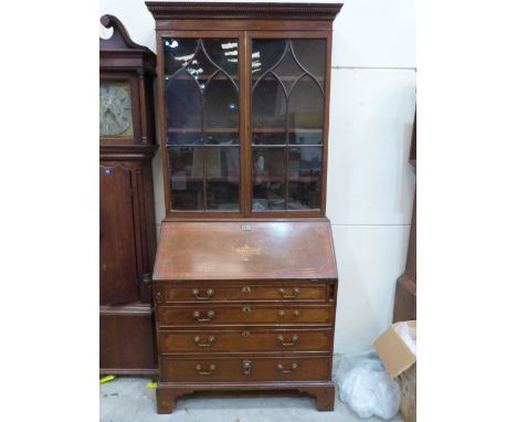 A George III mahogany and inlaid bureau bookcase, enclosed by a pair of astragal glazed doors over a sloping fall and four lo