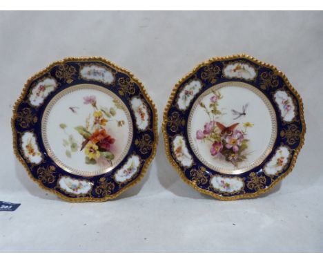 A pair of Royal Worcester cabinet plates gilded and painted in enamels with summer flowers to the centre and in six reserves 