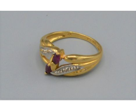 An 18ct gold ruby and diamond set ring with two Rubies flanked by diamonds, 3.1 grams, ring size K 