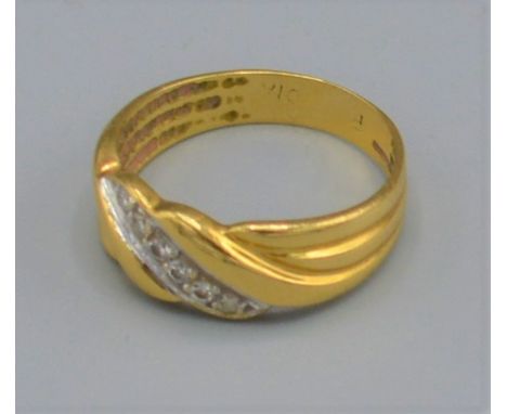 An 18ct gold diamond set band ring, with a row of six diamonds, 3.6 grams, ring size M 
