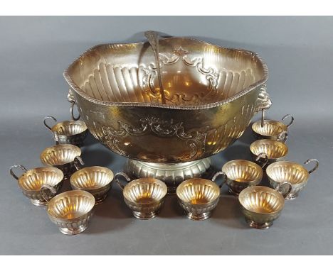 A silver plated punch bowl with cups and ladle 