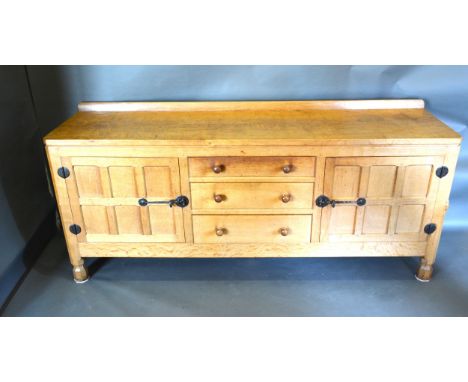 Robert (Mouseman) Thompson, An Oak Sideboard with a low galleried back and adze carved top above three central drawers flanke