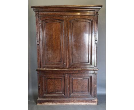 A 19th Century oak library bookcase, the moulded cornice above two arched panel doors, the lower section with two panel doors