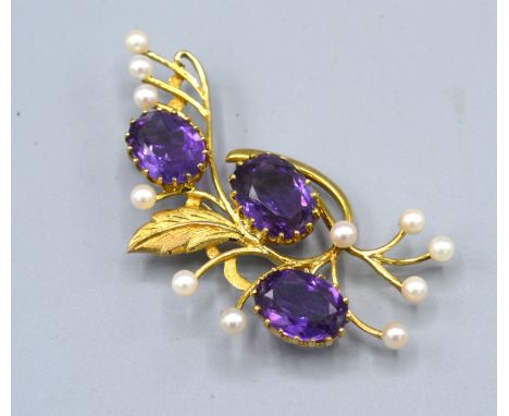 A 9ct. Gold Amethyst And Pearl Set Brooch of foliate spray form, 6.5cms long, 16.6gms. 
