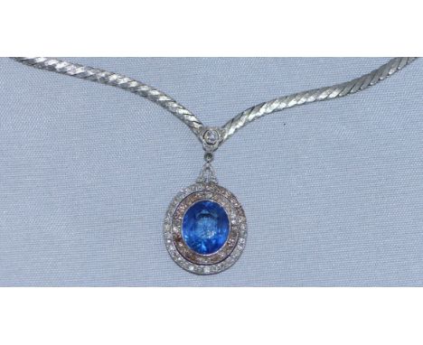 A sapphire and diamond oval pendant on flattened diagonal link chain set further small diamonds on central pendant clasp, sta