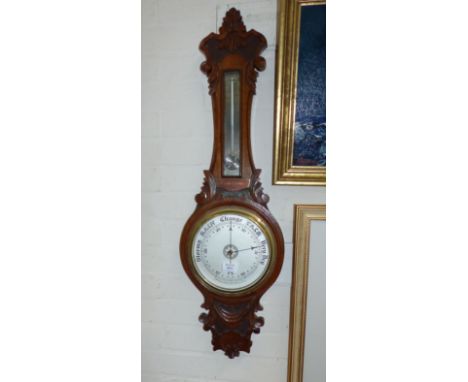A carved oak banjo barometer with aneroid movement and mercury thermometer with spiral reservoir, by R McQueen and Son Newcas