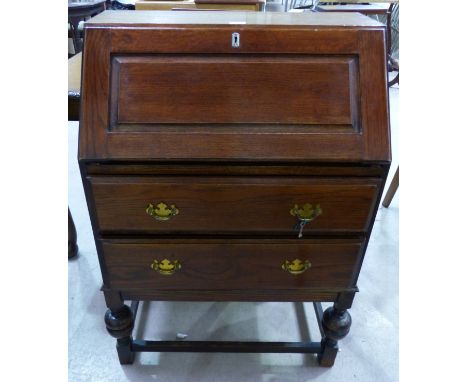 A 1930's oak fall front bureau with 2 drawers