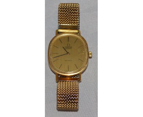 A gent's Omega De Ville 18 carat gold wristwatch with rounded square dial and button numerals, on woven plated strap