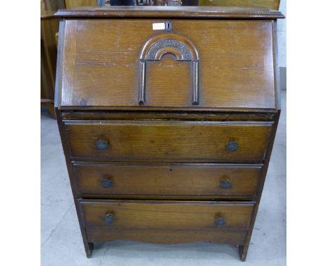 A 1930's oak fall front bureau with 4 drawers