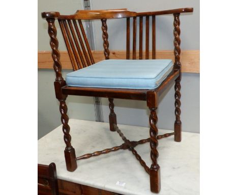 A 1920's stained wood corner chair on barley twist supports