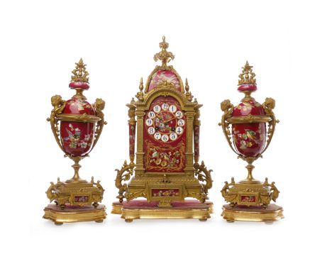 LATE 19TH CENTURY GILTMETAL AND CERAMIC CLOCK GARNITUREthe timepiece with arched cresting, ceramic dial below with Arabic num