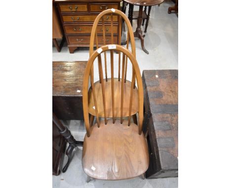 A pair of Ercol high hoop and stick back dining chairs