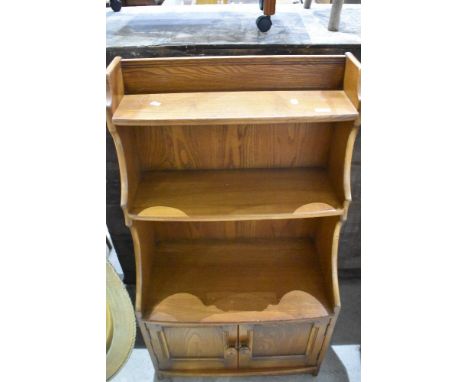 An Ercol or similar mid stained bookshelf with cupboard under, dimensions approx. W61 D35 H111cm