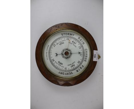 A vintage oak framed circular aneroid barometer. 23cm diameter
