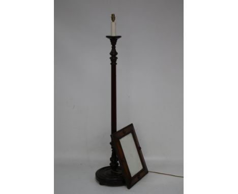 A standard lamp and oak mirror. An oak framed bevelled edge mirror with roundal and moulded decoration. The lamp has a reeded